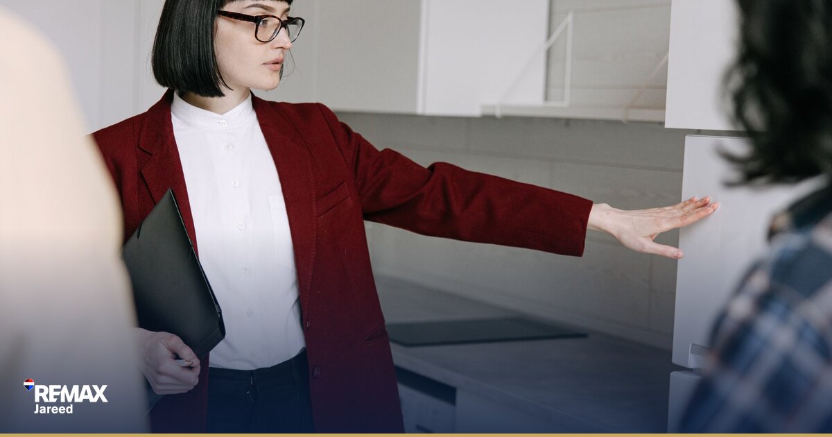 Two real estate professionals shaking hands in contemporary office setting symbolizing partnership and career advancement