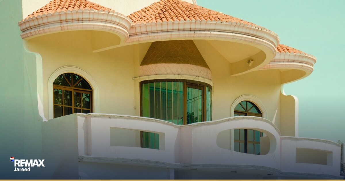 وكيل عقاري يعمل على حاسوب محمول في مكتب RE/MAX بالقاهرة أثناء متابعة صفقات العملاء