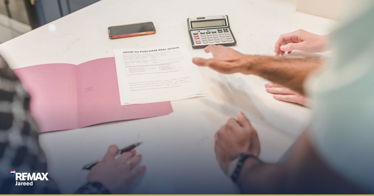 Banker reviewing mortgage pre-approval documents with Egyptian couple at modern bank office desk