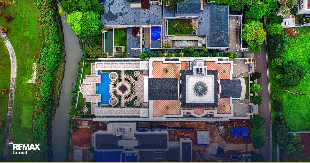 Aerial view of a gated residential compound in Sheikh Zayed with landscaped gardens, swimming pools, and mid-rise apartment buildings