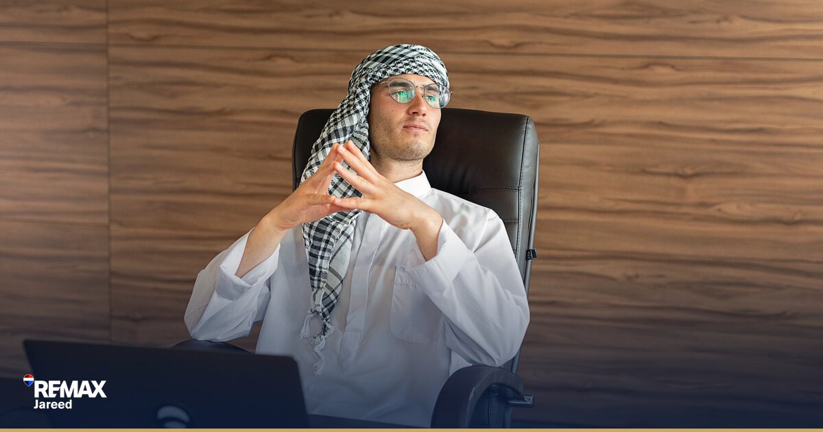 وكيل عقاري يُراجع بيانات السوق والأسعار في مكتب RE/MAX لتطوير مهاراته في الشيخ زايد