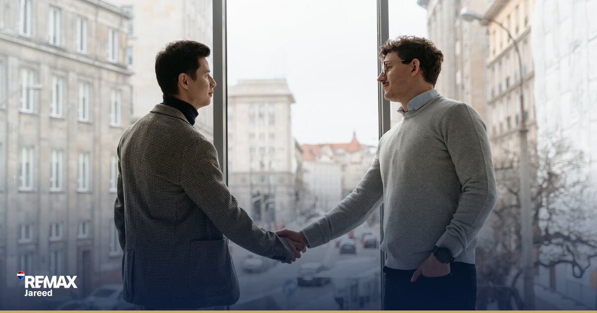 وكيل عقاري يستخدم تطبيق CRM على جهاز لوحي في مكتب حديث لإدارة استفسارات العملاء