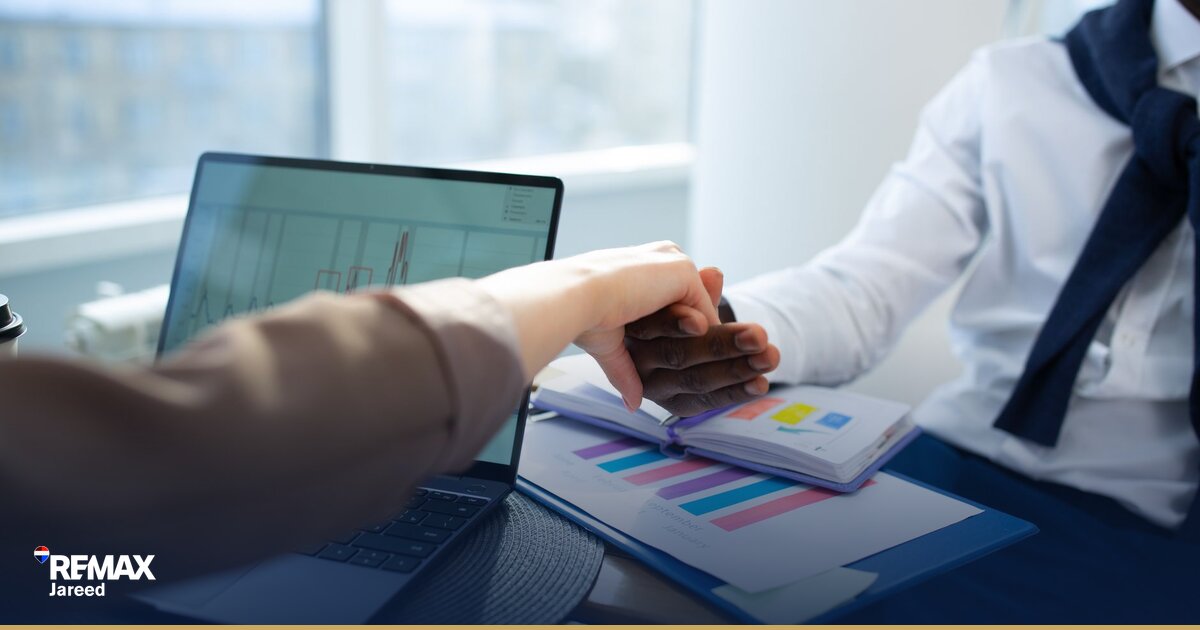 وكيل عقاري يعرض وحدة سكنية على عميل في مكتب عصري بالشيخ زايد