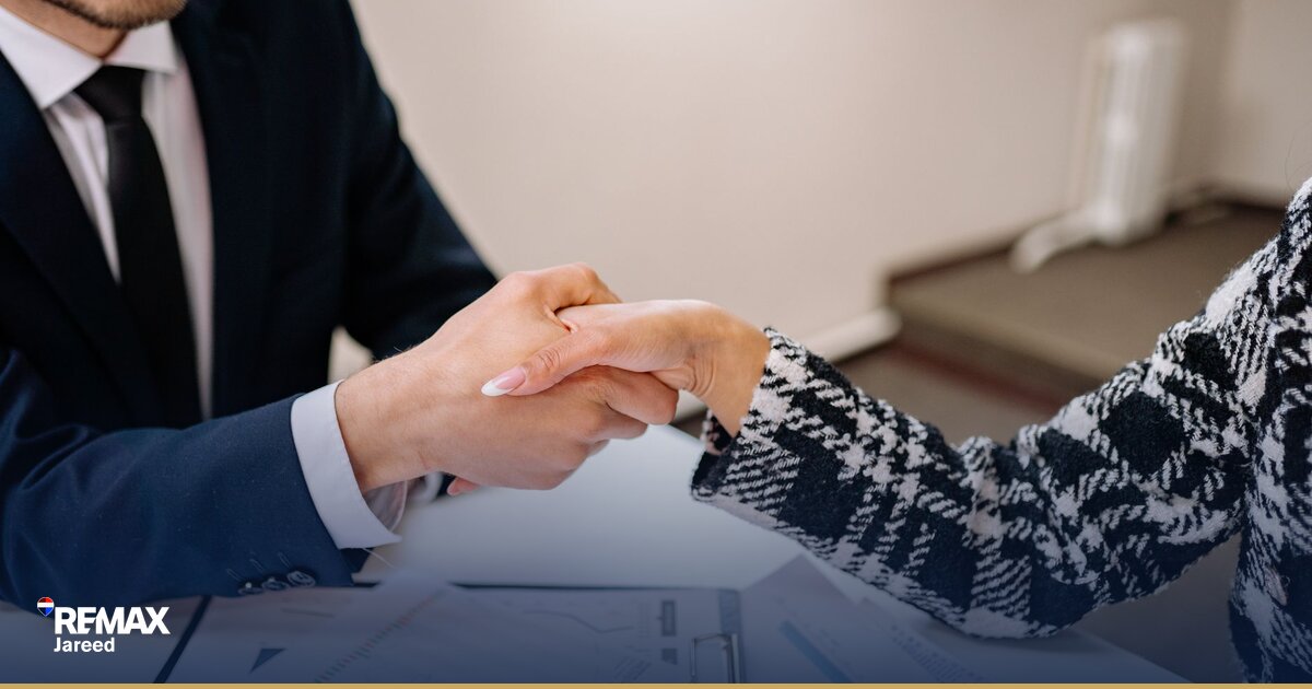 مصافحة بين وكيل عقاري وعميل أثناء توقيع عقد بيع وحدة سكنية تُمثّل إتمام صفقة عقارية بسيولة عالية