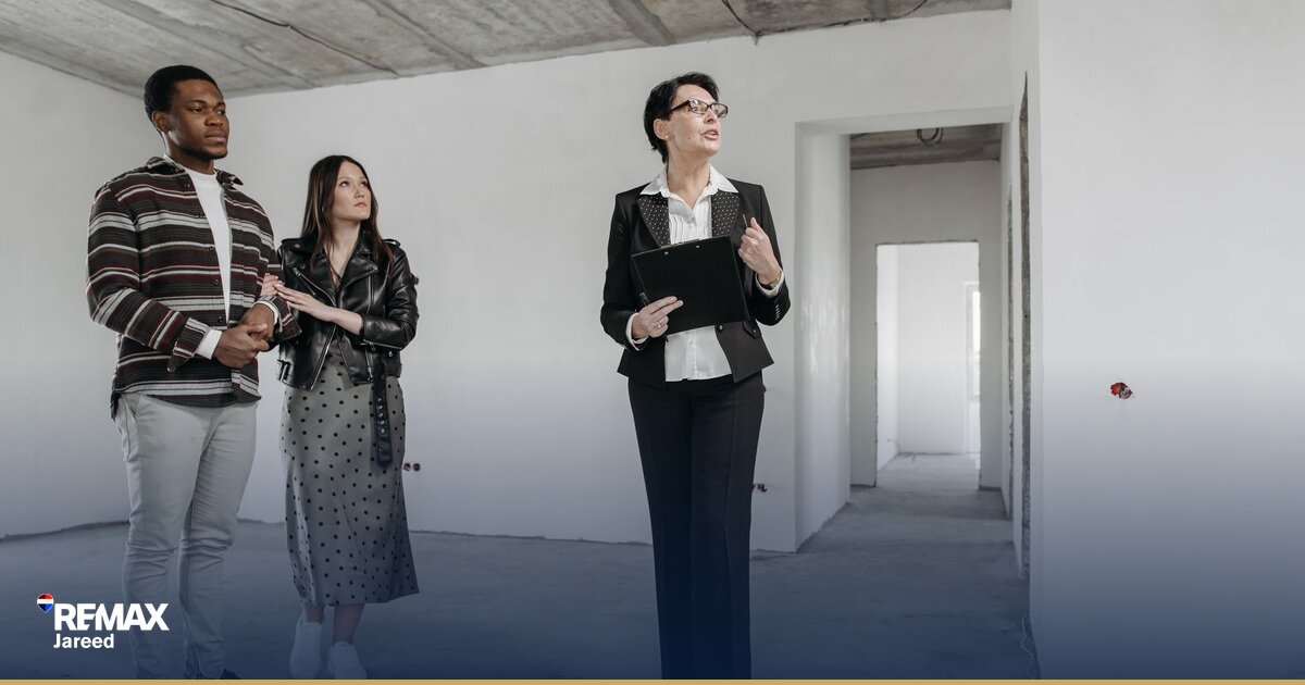 Property consultant presenting modern apartment to prospective buyers during viewing tour