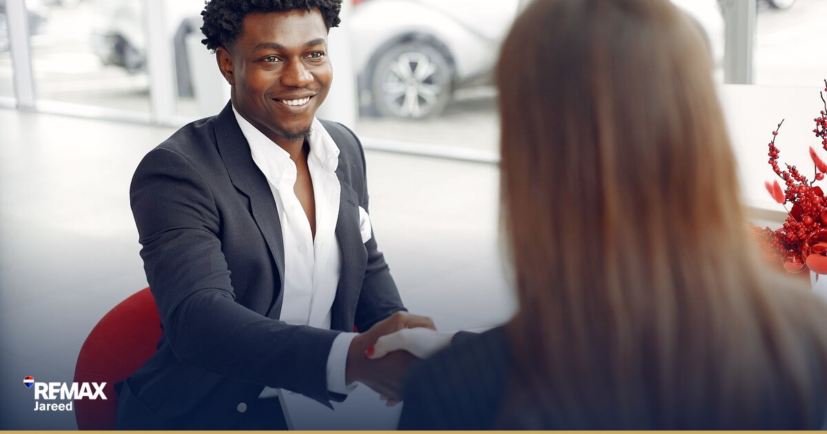 Professional handshake over signed contract symbolizing successful property negotiation in Sheikh Zayed real estate market