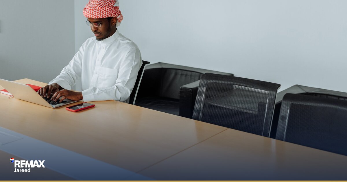 وكيل عقاري يحسب خسارته المالية على مكتب مع أوراق وآلة حاسبة في مكتب عقارات
