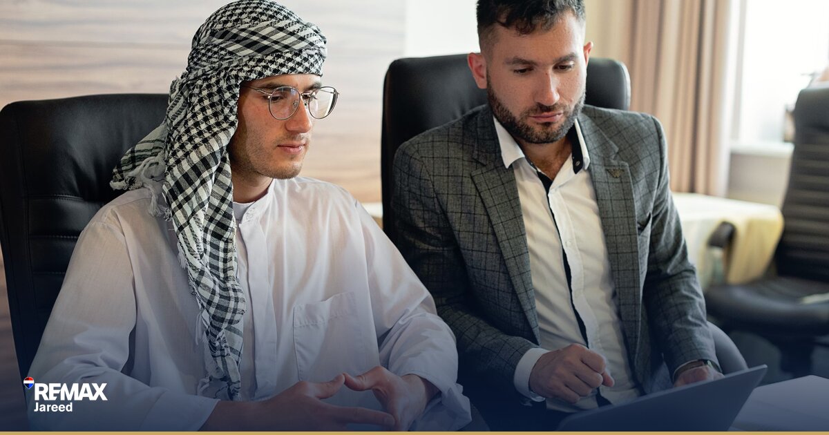 وكيل عقاريّ يجري مكالمة هاتفية مع عميل محتمل في مكتب عقارات حديث