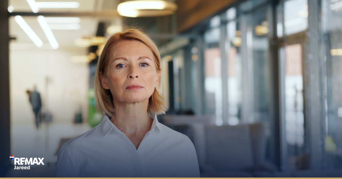 وكيل عقاري يحسب العمولات على مكتب في 6 أكتوبر بجانب آلة حاسبة وأوراق عقود