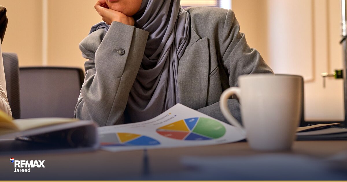 مُصافحة بين مُشترٍ وبائع عقار أثناء التفاوض على صفقة في مَكتب عصريّ بالشيخ زايد