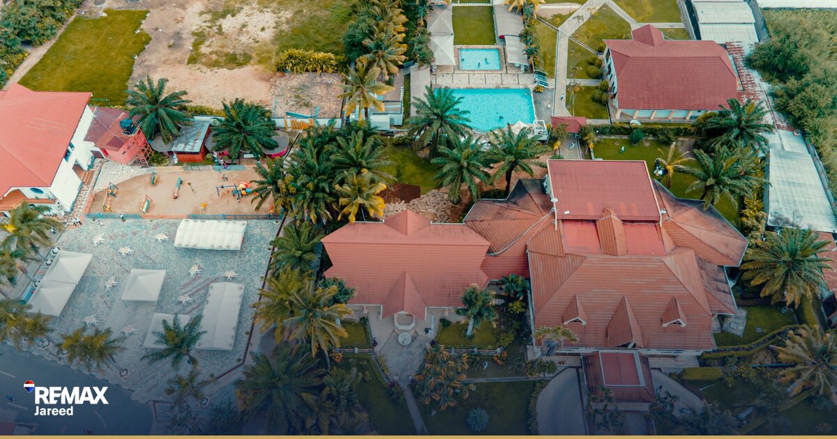 Aerial view comparing modern mid-rise compound and golf course villa community in Sheikh Zayed Egypt